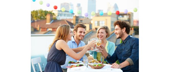 Group Of Friends Eating Meal On Rooftop Terrace