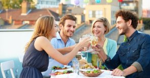 Group Of Friends Eating Meal On Rooftop Terrace Group Of Friends Eating Meal On Rooftop Terrace