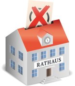 Rathaus als Wahlurne symbolisch mit Wahlzettel und Kreuz Rathaus als Wahlurne symbolisch mit Wahlzettel und Kreuz